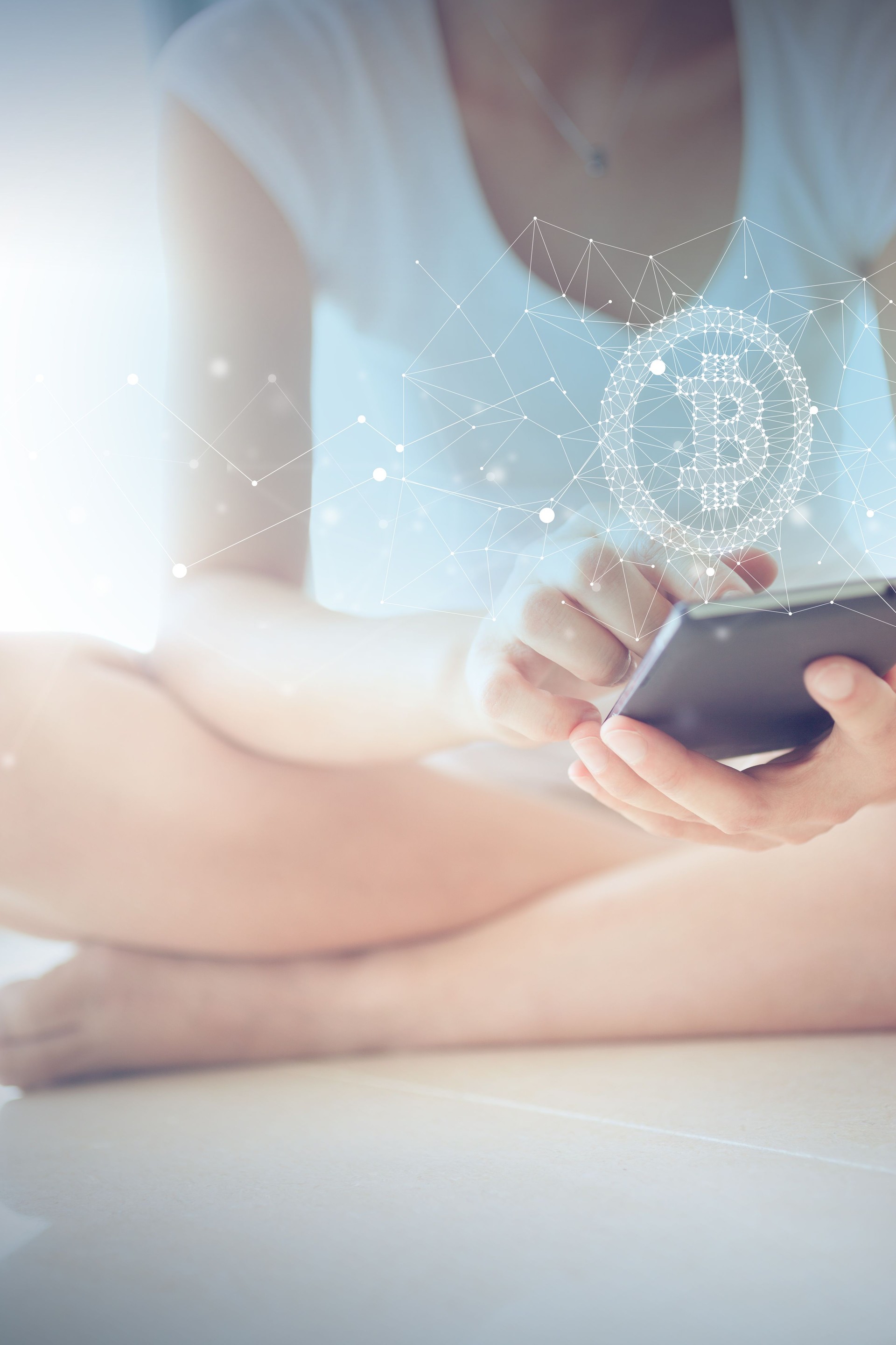 Woman Sitting on Floor Using Smart Phone with Bitcoin Symbol Floating on Screen